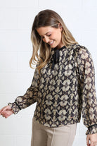Rant & Rave Maria Top in gold, angled model view showing printed fabric and tie neckline