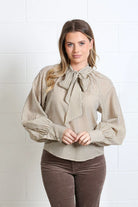 Rant & Rave Natalia top in Light Coffee, front model view showing tie neck and striped blouse detail.