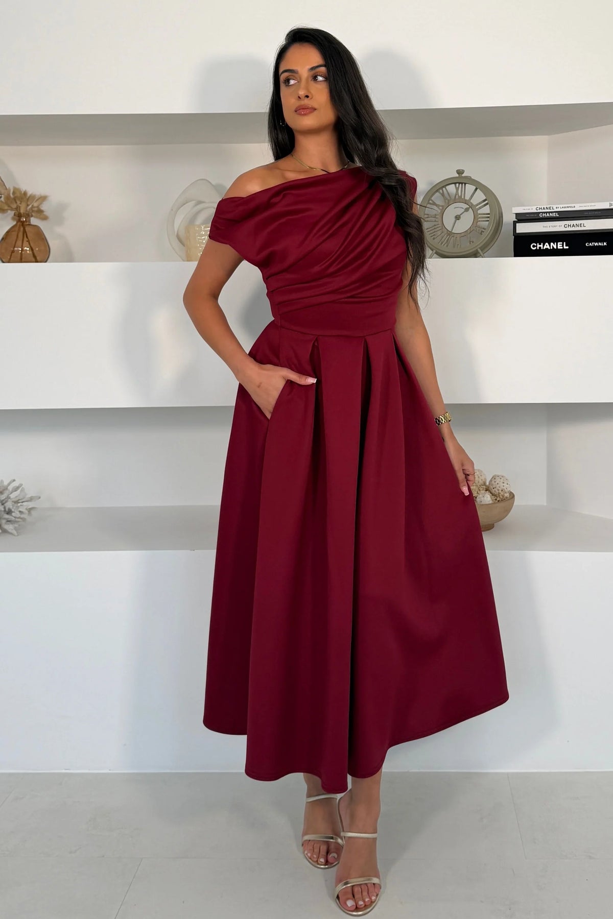 Girl In Mind Betty asymmetric neckline skater midi dress in wine, worn by model, front view showing off - shoulder neckline and pleated skirt