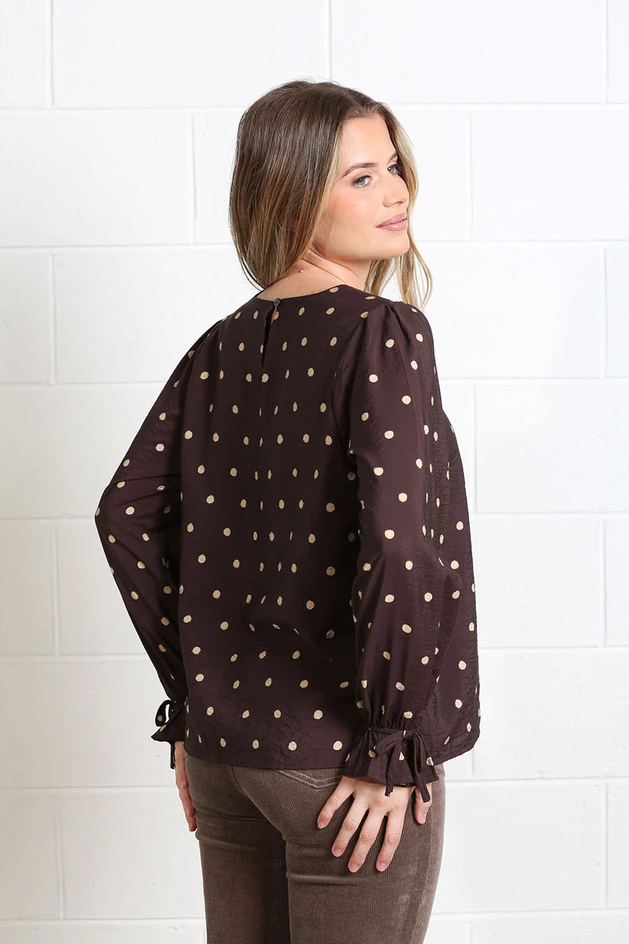 Rant & Rave Sophia Top Chocolate Dot, back view showing keyhole neckline and tie cuffs worn by model.