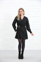 Rant & Rave Susannah Wrap Dress in black, front view worn by a model showing gold buckle belt and V - neckline