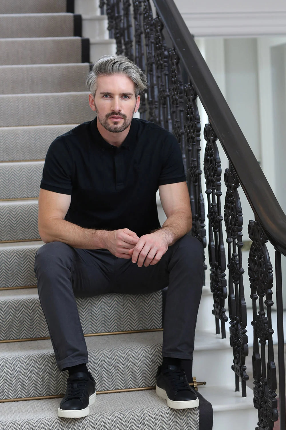 Kenrow Vinny Polo in black worn by model sitting on stairs