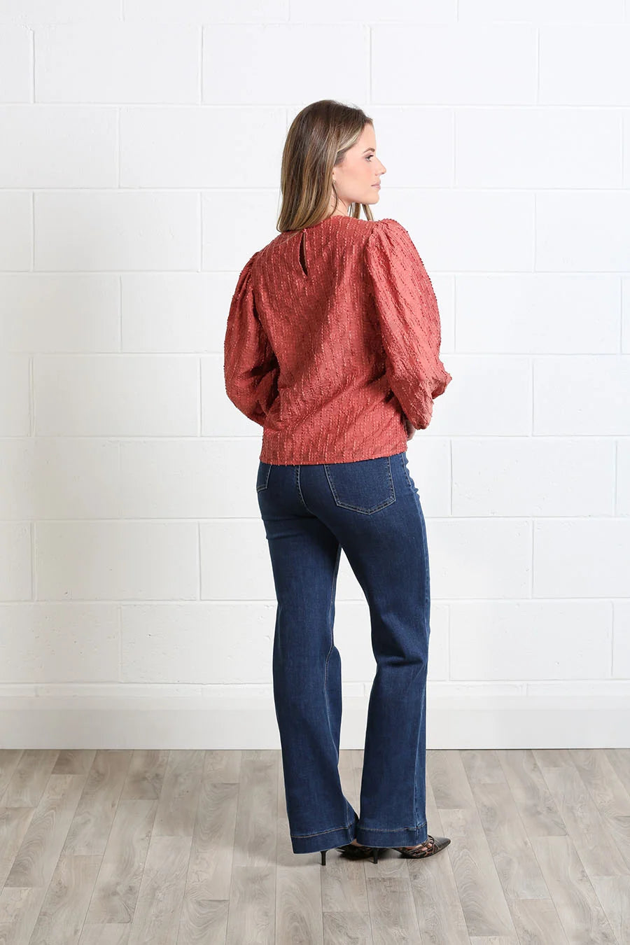 Rant & Rave Zeta Top in terracotta, back model view with textured fabric and long puff sleeves.