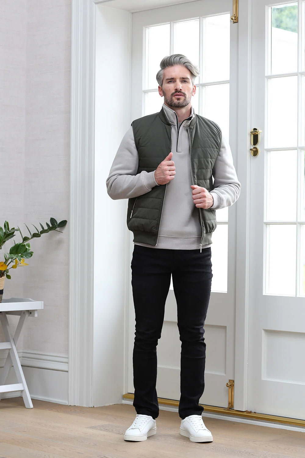 Kenrow Andy Gilet in light khaki worn by model adjusting the front zip, front model view