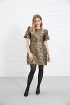 Rant & Rave Evelyn Dress in black and gold floral jacquard, front view worn by model with one hand on thigh.