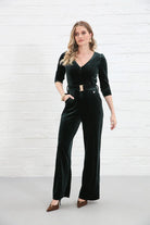 Rant & Rave Farrah Jumpsuit in green velvet, angled model view with one hand in pocket