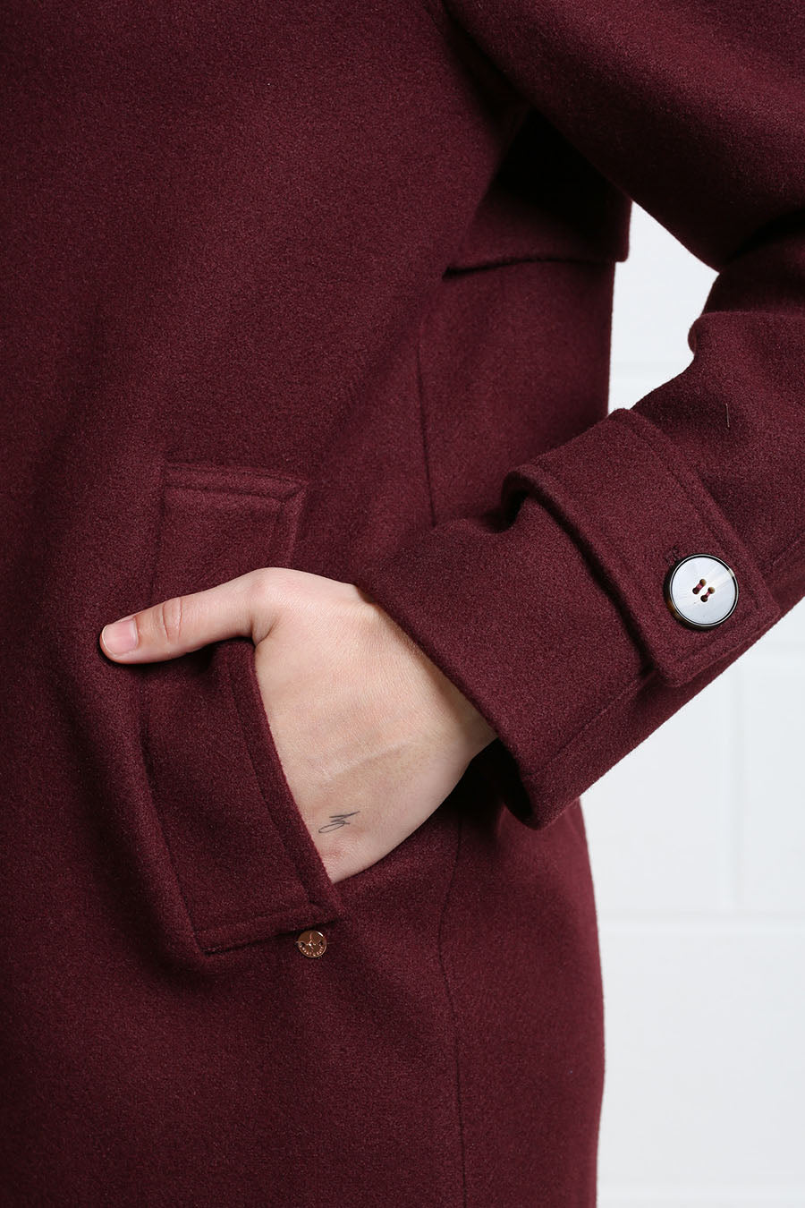 Detail view of Rant & Rave Georgia Coat deep port fabric, pocket and buttoned cuff tab