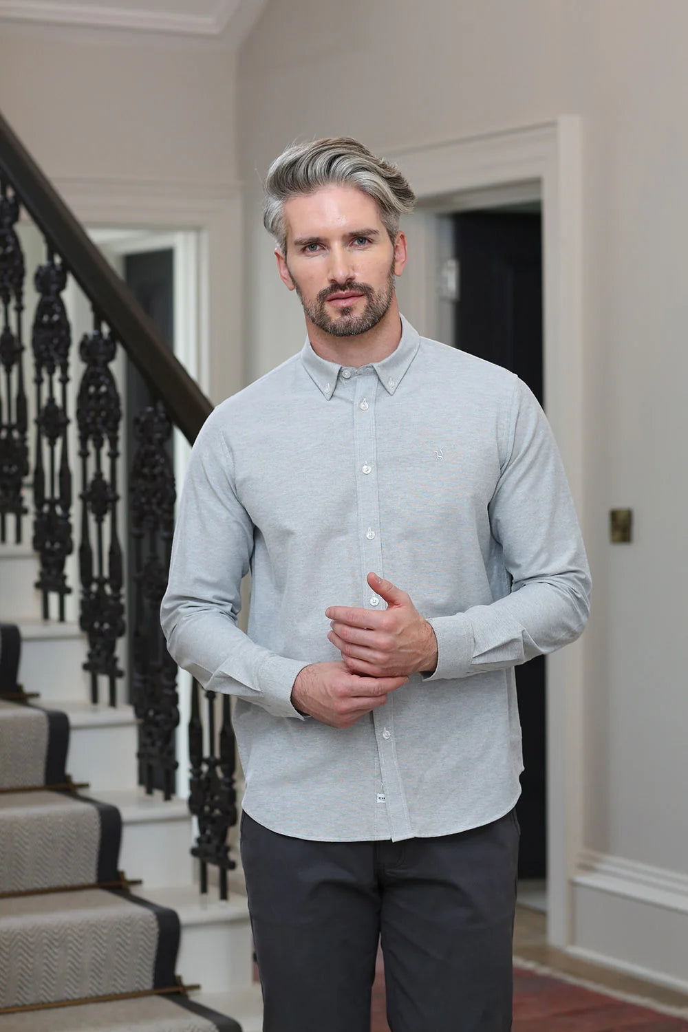 Kenrow Fritz Shirt in light grey worn by model, angled front view near staircase.