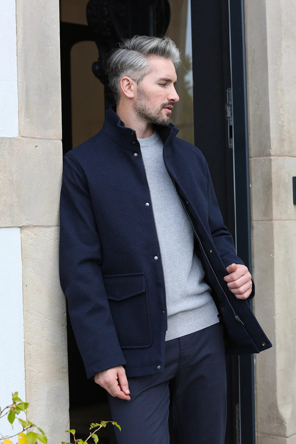 Kenrow Huxley Coat in navy, side model view with hand in pocket and collar detail visible