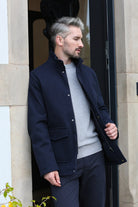 Kenrow Huxley Coat in navy, side model view with hand in pocket and collar detail visible