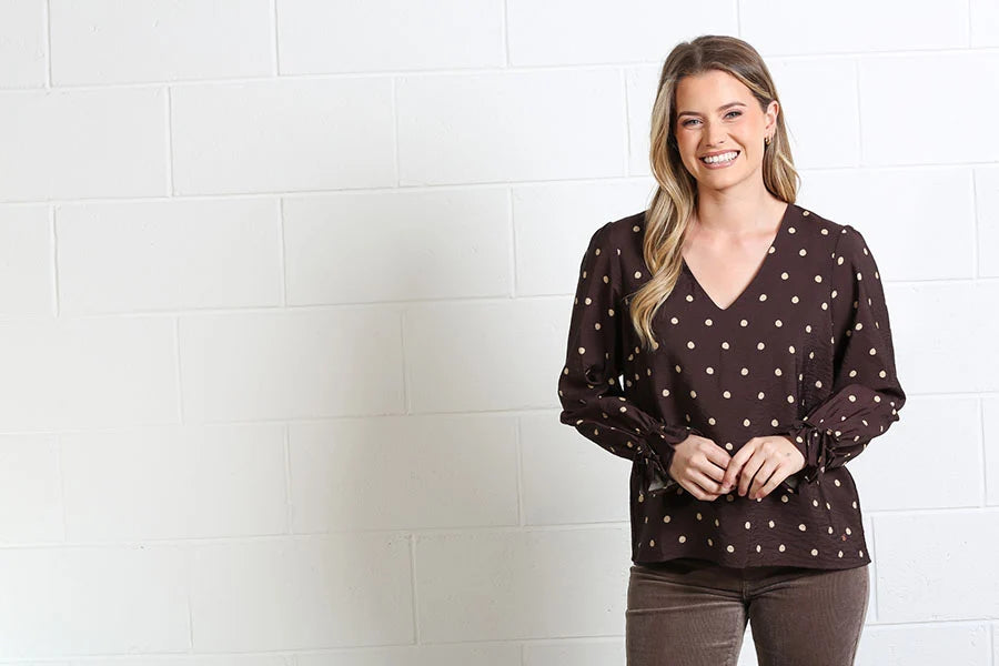 Rant & Rave Sophia Top Chocolate Dot, front view worn by smiling model with V-neck and spot pattern.