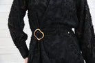 Detail view of the Rant & Rave Susannah Wrap Dress in black showing the gold buckle belt and textured floral fabric