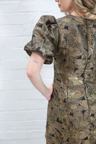 Rant & Rave Evelyn Dress in black and gold floral jacquard, back detail view showing puff sleeve, back seam and floral pattern.