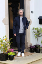 Kenrow Huxley Coat in navy worn by a model, full - length front view with hands in pockets