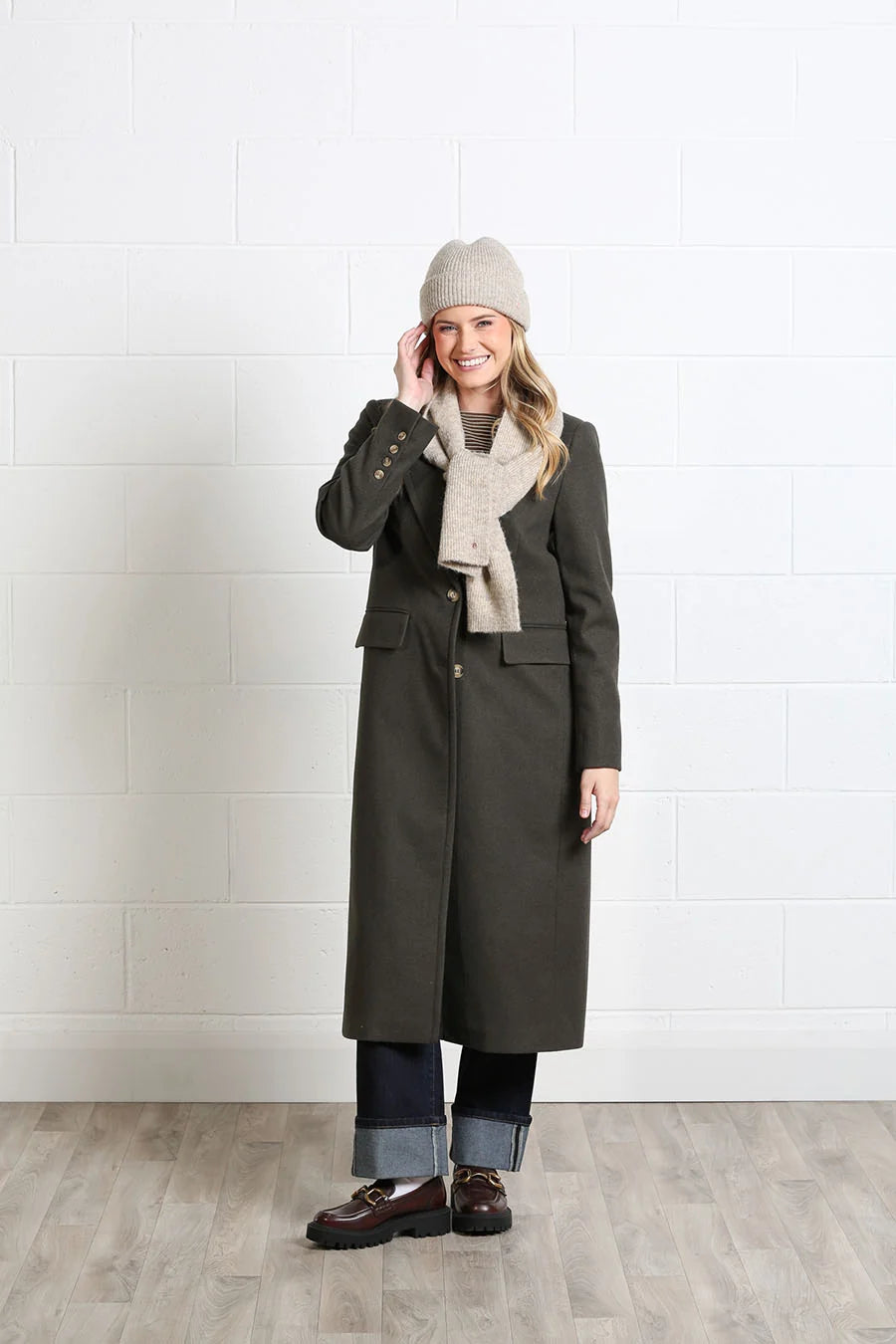 Rant & Rave Olivia Coat deep moss worn by model with beige scarf and knit hat, front view