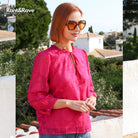 Rant & Rave Primrose top in cerise worn by model, close - up angled view with tie neckline