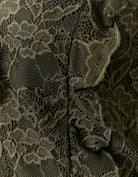 Detail view of the green lace fabric and ruffle trim on the Tally Weijl khaki lace top