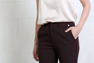 Rant & Rave Valerie Slim Trouser in aubergine, detail view of front waistband, button and pocket