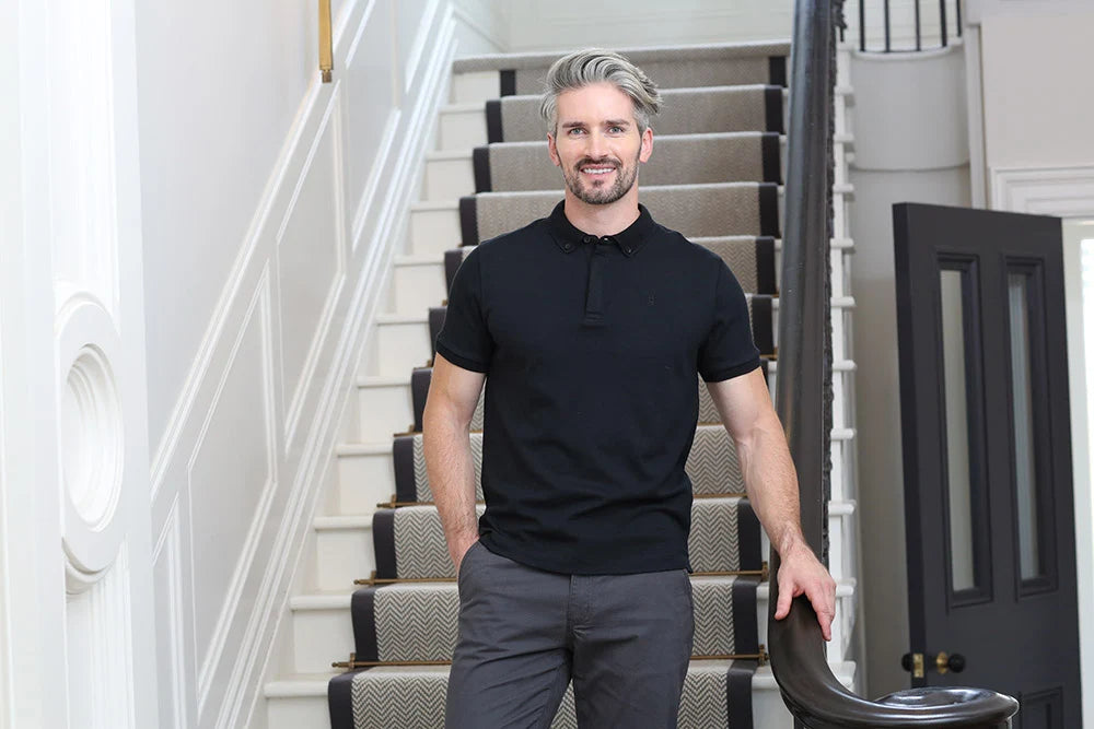 Kenrow Vinny Polo in black worn by model standing by staircase railing
