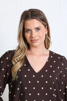 Model wearing Rant & Rave Sophia Top in chocolate dot print, close - up front view of V - neckline.