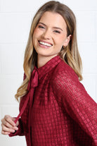 Rant & Rave Vivian Shirt in burgundy, model view showing the pussybow neck tie and smiling face