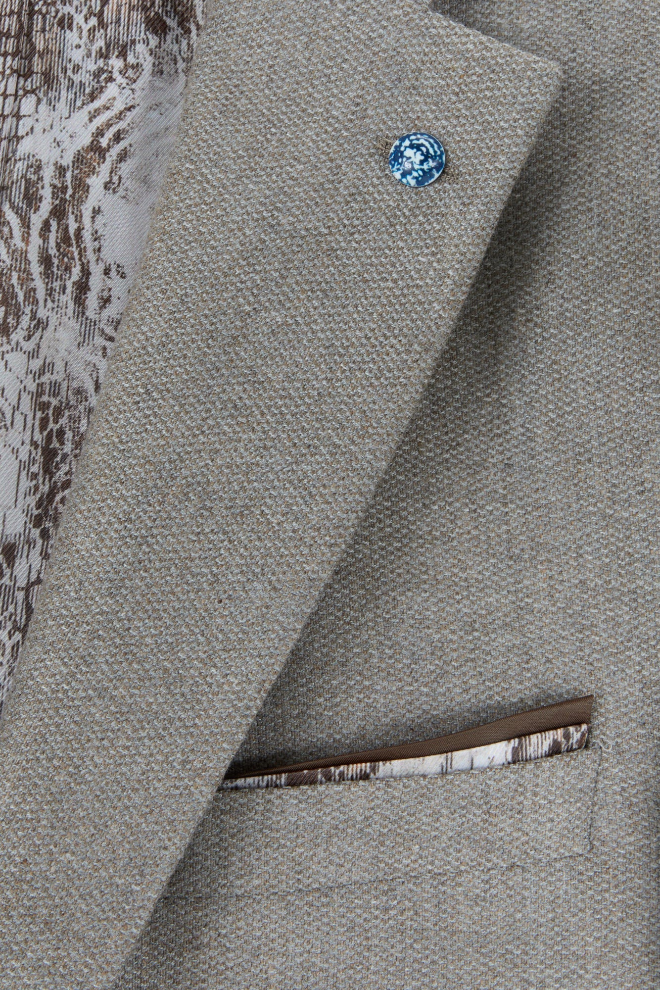 Close-up of the Pisa Stone blazer lapel pin, pocket square and lining