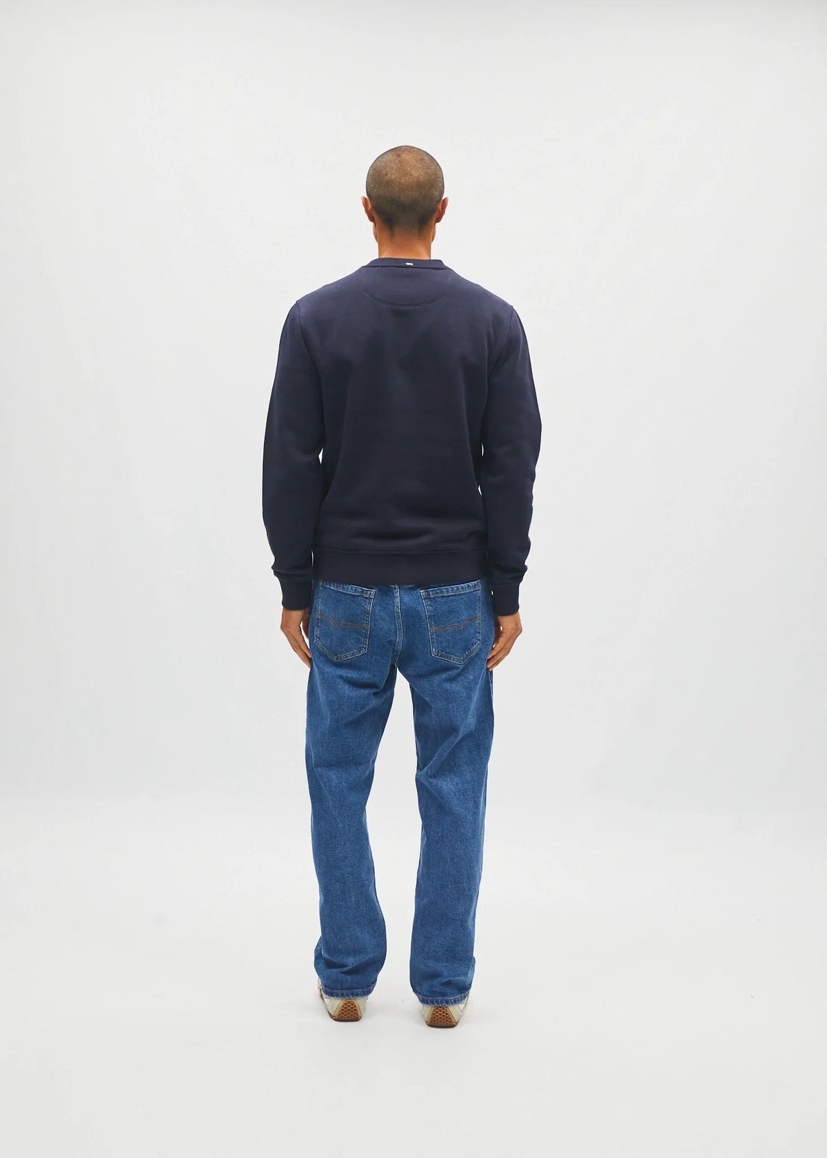Diesel Jan Sweatshirt Metro Navy worn by model, back view with blue jeans and cream sneakers