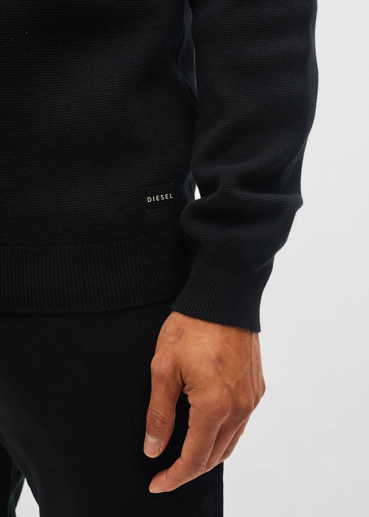 Diesel logo patch detail on the hem of the Tully Half Zip sweater