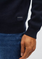 Detail view of Diesel Tully Half Zip sweater showing navy body, ribbed cuff and Diesel logo patch.