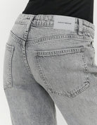 Detail of Tally Weijl grey low waist straight leg jeans back pocket and logo patch