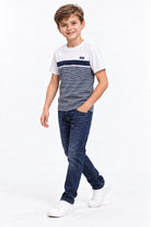 Boy wearing Diesel Ryan raw indigo jeans, three-quarter view styled with the Lenno white and blue T-shirt.