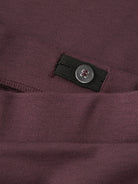 Close-up of the button and elastic inside the waistband of NAME IT Frikkali trousers in Catawba Grape