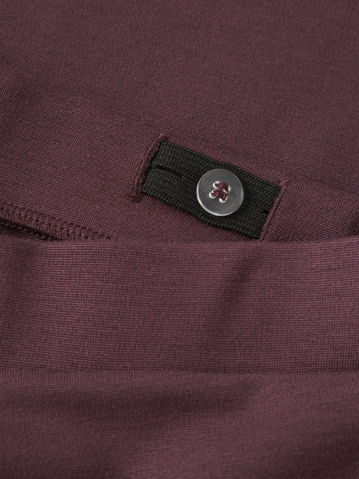Close-up of the button and elastic inside the waistband of NAME IT Frikkali trousers in Catawba Grape