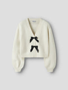 Angled view of NAME IT Rina Long Sleeve Knit Cardigan in Antique White Black Bow