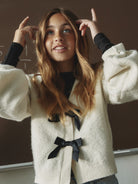 NAME IT Rina Long Sleeve Knit Cardigan in Antique White Black Bow lifestyle model view