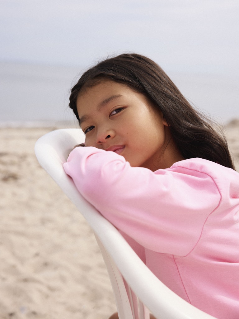 NAME IT Harmonia  pink drink sweatshirt side view on girl sitting on white chair