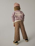Back view of a model wearing NAME IT Rammie wide-leg dot-print sweatpants in Coca Mocha