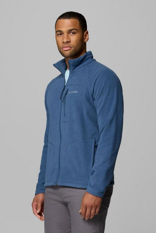 Man wearing a blue fleece jacket on a gray background
