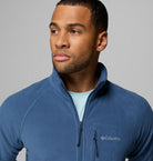 Man wearing a blue Columbia jacket against a gray background