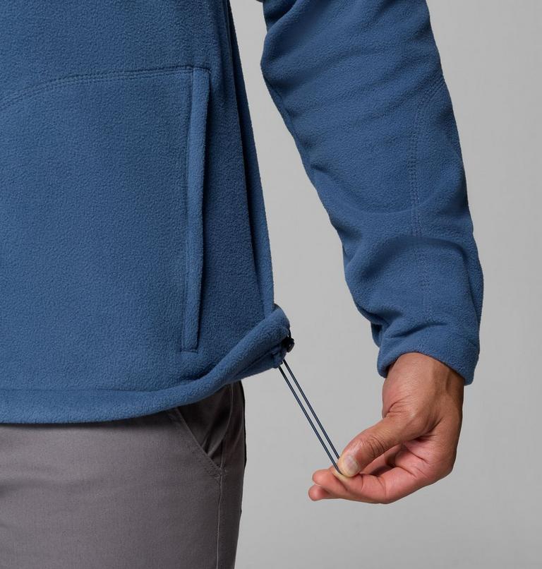 Person wearing a blue fleece jacket with a gray background