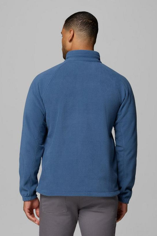 Man wearing a blue fleece jacket on a gray background