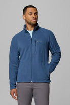 Man wearing a blue fleece jacket with Columbia logo on a gray background