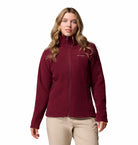 Woman wearing a maroon Columbia fleece jacket on a white background