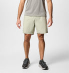 Person wearing light-colored shorts and black shoes on a white background