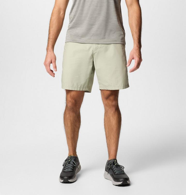 Person wearing light-colored shorts and black shoes on a white background