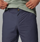 Navy pants with a green shirt on a gray background