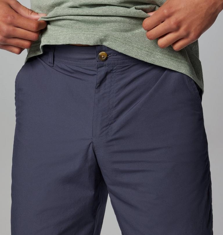 Navy pants with a green shirt on a gray background