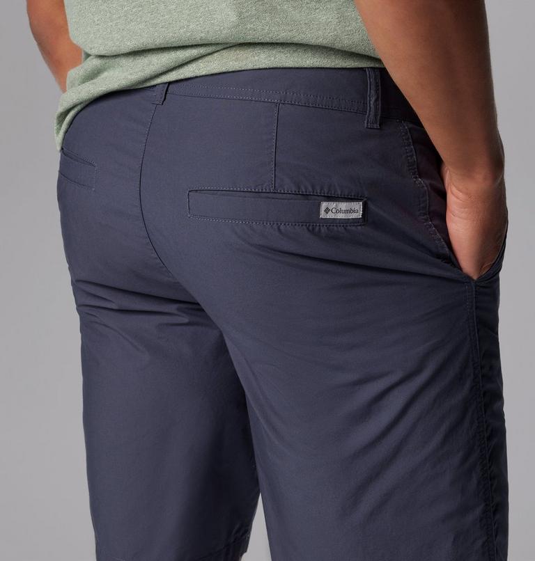 Navy pants with a brand logo on the pocket against a gray background