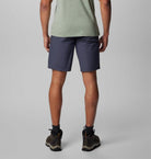 Person wearing navy shorts on a plain background