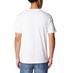 Person wearing a plain white t-shirt on a white background
